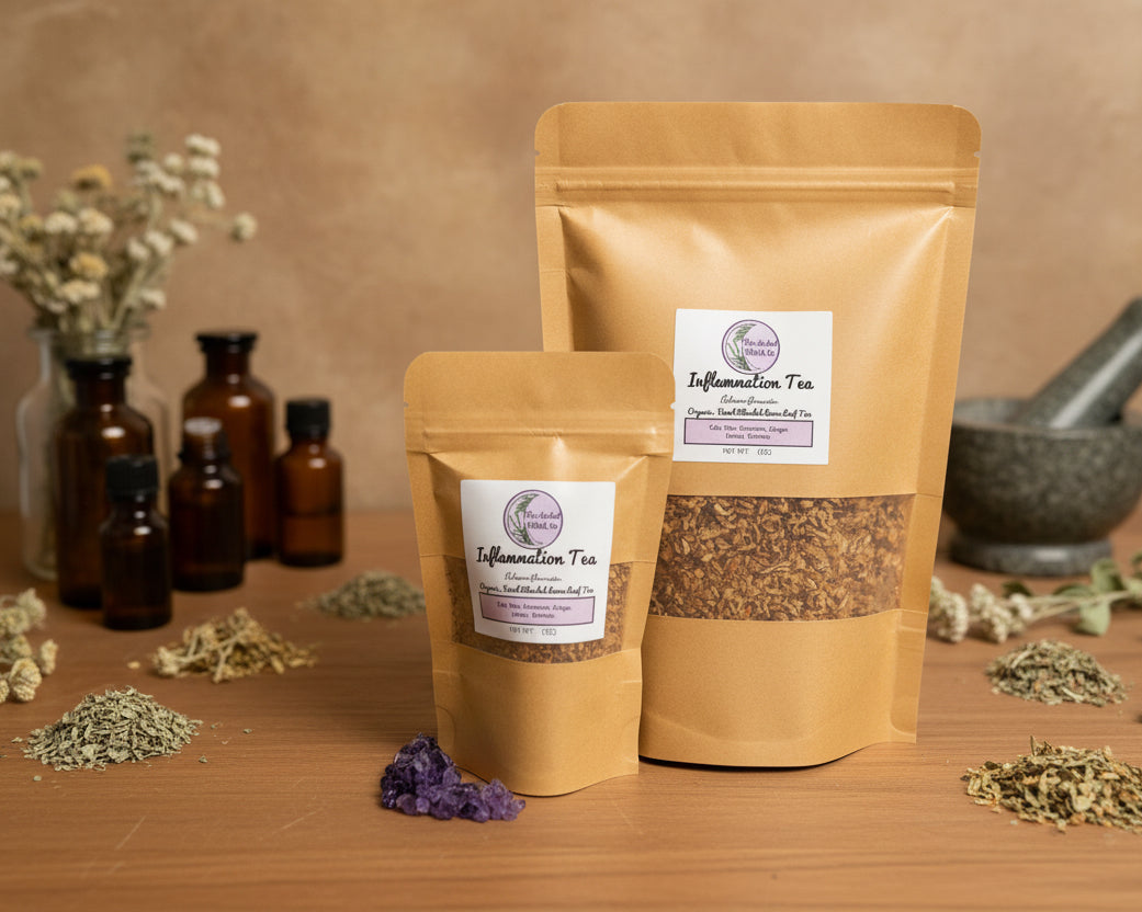 Two stand-up pouches of inflammation tea one small and one large, displayed on a dark wooden table.