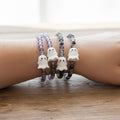 beaded stretch bracelets worn on a wrist.  with white ghost charms.