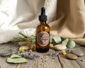 An amber glass dropper bottle of essential oil with a black cap and a round label 