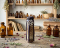 A small glass bottle with a silver pentagram charm, standing on a wooden surface