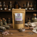 A kraft paper stand-up pouch labeled 'Smudging Incense' with a clear window showing loose incense pieces, alongside a small open metal tin of the incense blend and pink stones 